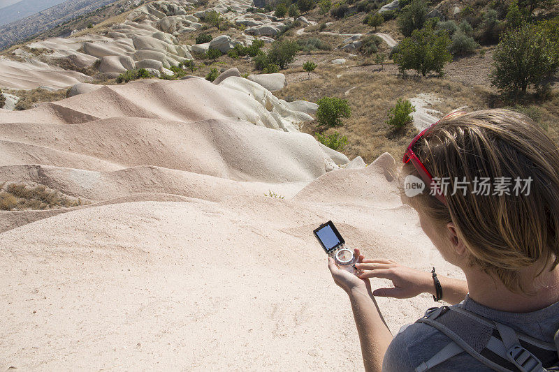 徒步旅行者在砂岩山使用指南针。