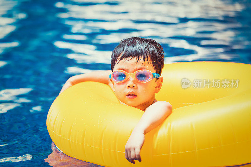 一个兴高采烈的孩子在游泳池里游泳