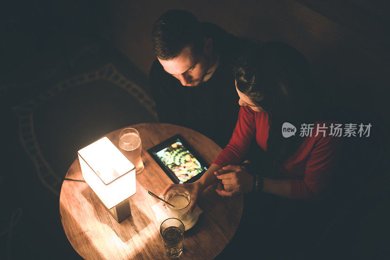 一对年轻夫妇在咖啡馆里使用无线技术。