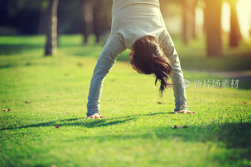 健康的生活方式妇女在公园草地上练习倒立