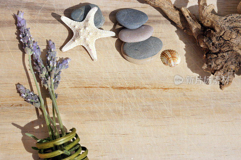 在木桌上放一束薰衣草、海石和一只海星，为你的文本提供复印空间