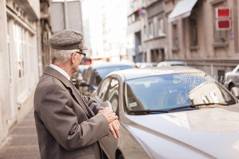 老人在街上等出租车。