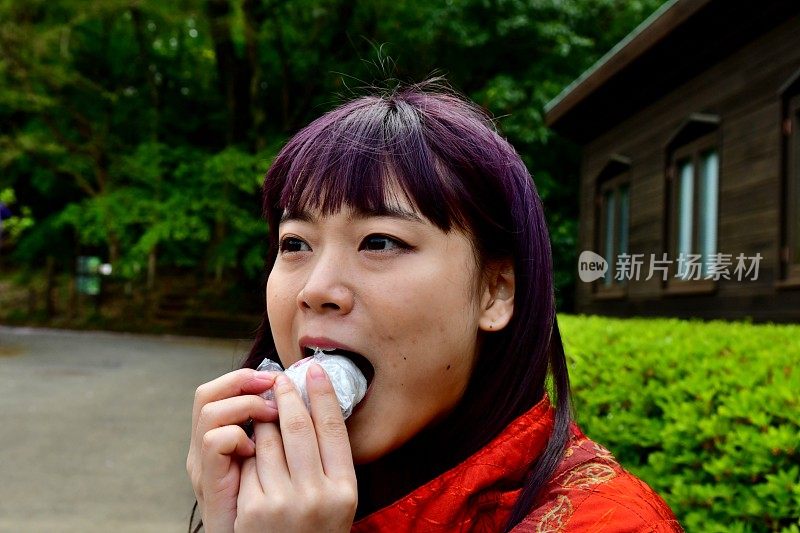 一名年轻的日本女子在花见之后享用樱花蛋糕