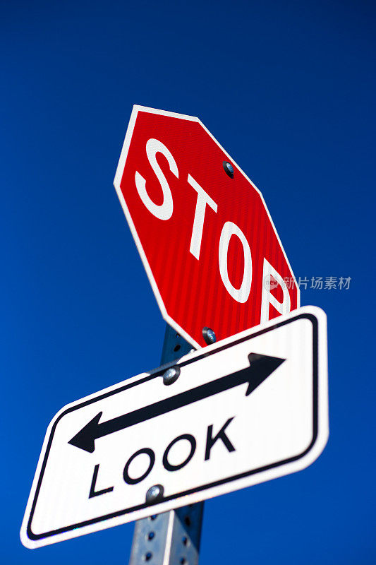 “停止”标志在“看”标志(在铁路)上面，蓝色背景