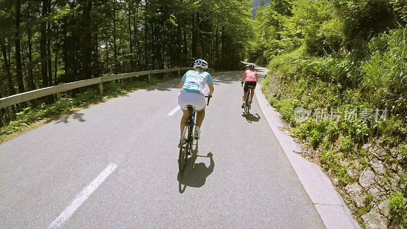 两名妇女在山路上骑公路自行车