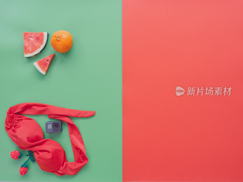 夏季配饰和女装概念从红色比基尼、动感相机、热带水果有西瓜和橙色，在绿色和红色的背景上用柔和的颜色做广告销售产品。