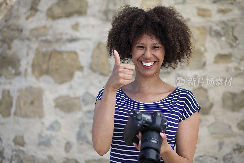 非裔美国女摄影师用数码单反竖起大拇指