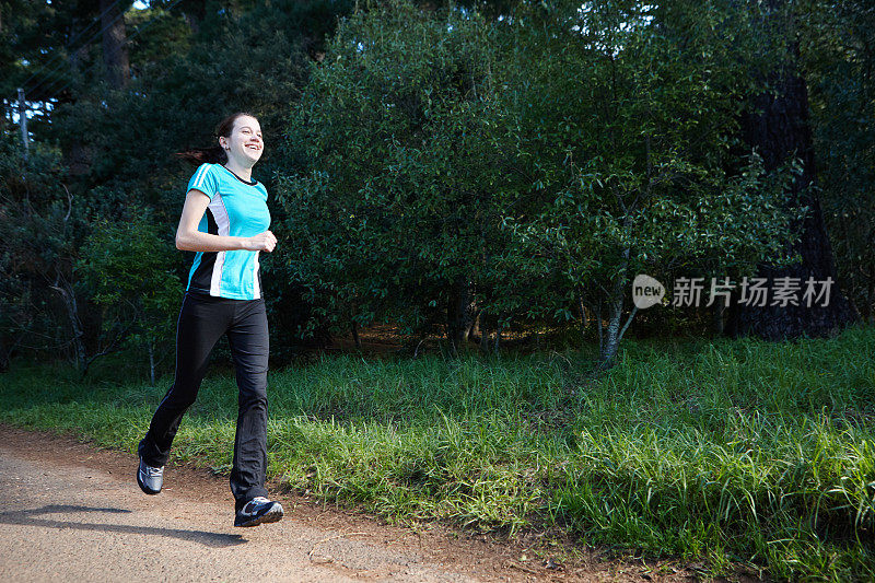 美丽的年轻女子在森林里奔跑以保持健康