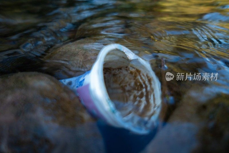 塑料杯漂浮在河面上的照片