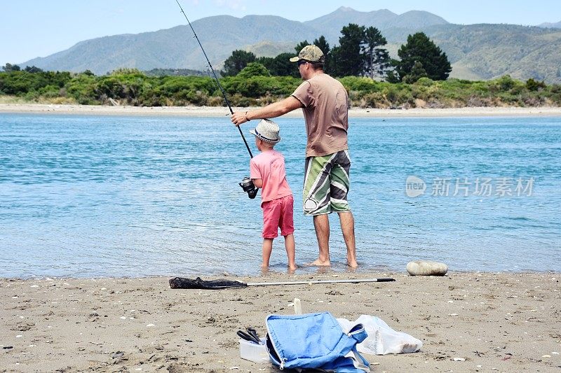 父亲和孩子在海岸河口钓鱼