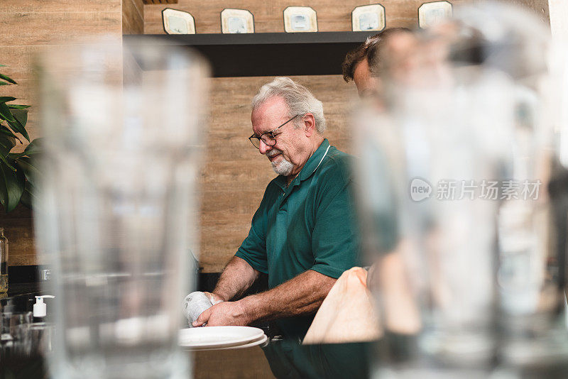 一个老人在吃午饭的时候洗碗