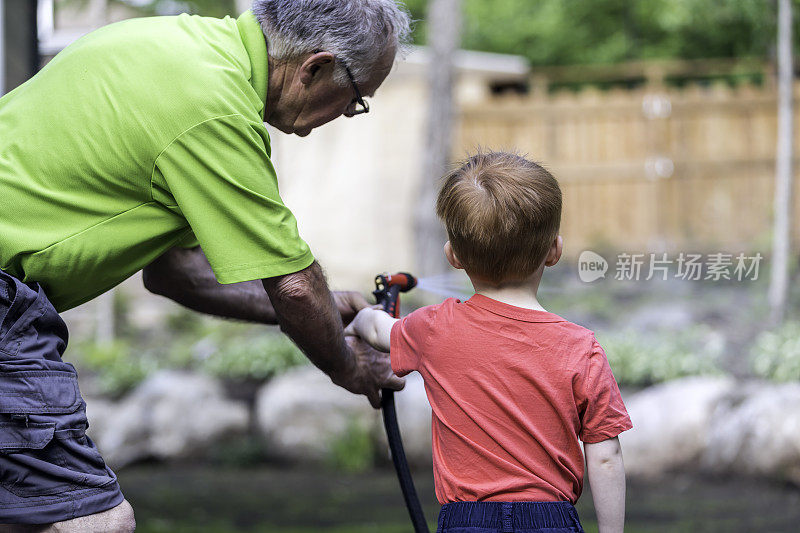 爷爷和孙子在夏天给花园浇水