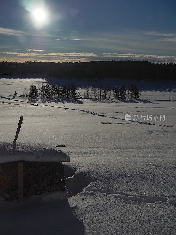 芬兰拉普兰的风景，有雪、森林和冰冻的河流
