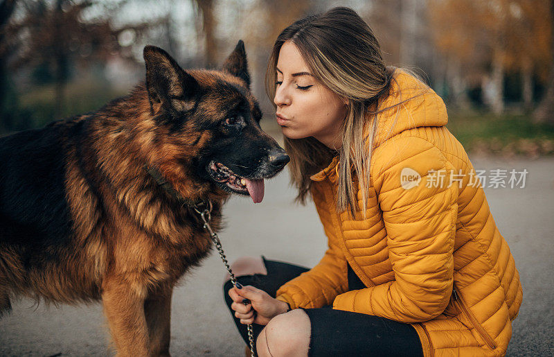 年轻女子和德国牧羊犬在公园里玩