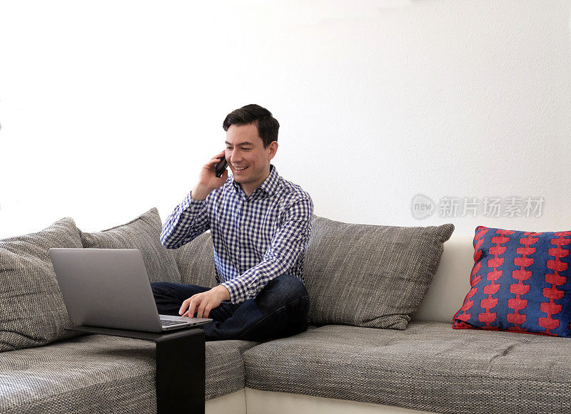 一个人在家工作，客厅里有台笔记本电脑