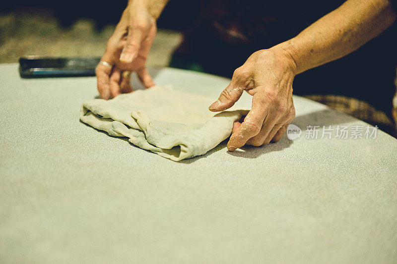 一个女人正在客厅里用电子设备做馅饼