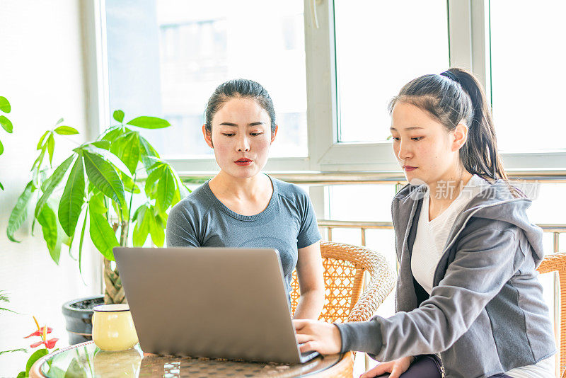 两个年轻的亚洲妇女正在讨论工作计划