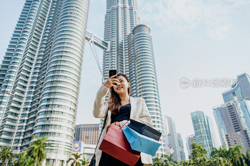 年轻的亚洲女商人下班后购物和自拍