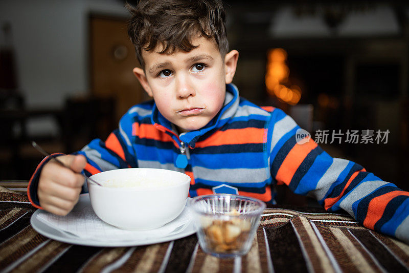 一个可爱的男孩，他的脸颊因为在滑雪小屋吃冷而变红