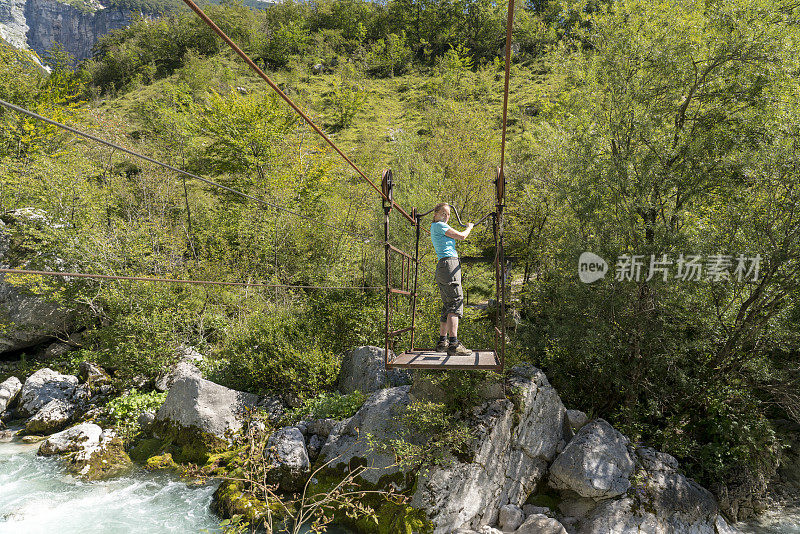 女性乘坐手动缆车穿越托明卡河