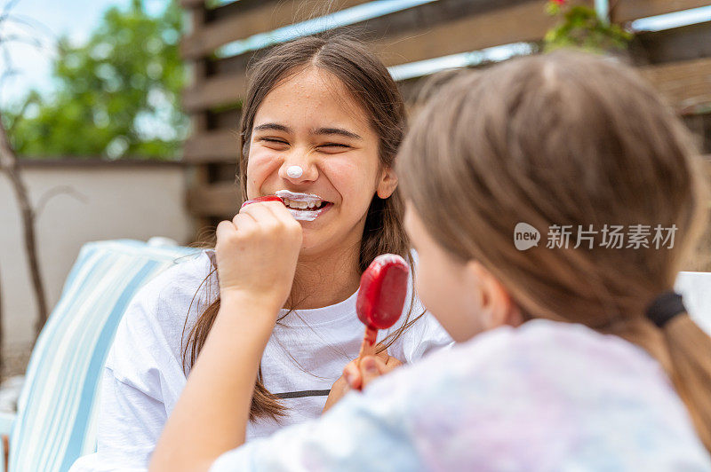 两个女孩在享受冰淇淋，还用它当口红