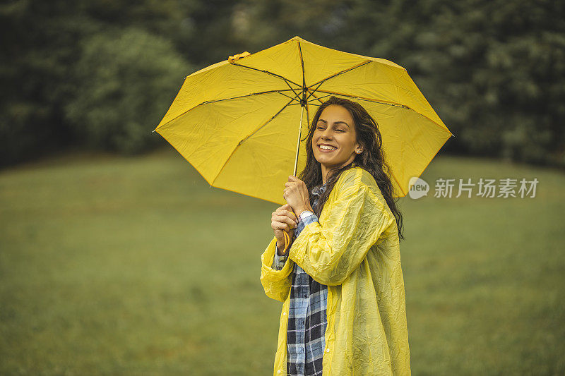 快乐的女人微笑着行走在雨天