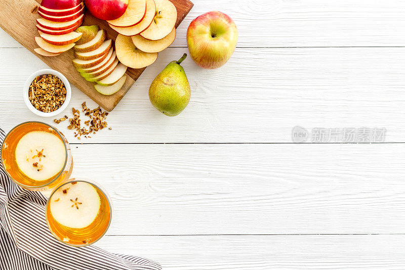 从上方的复印空间，白色木质桌子上放着苹果和梨等水果饮料