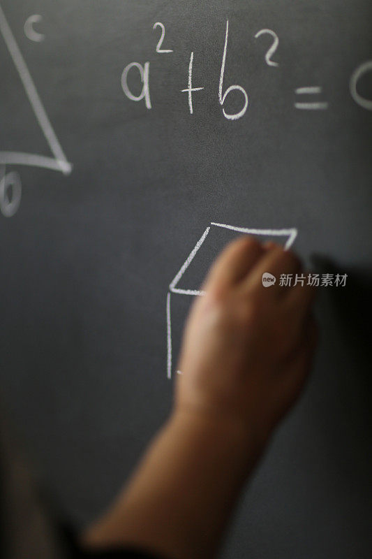 手持粉笔，在黑板上写下复杂复杂的数学公式。