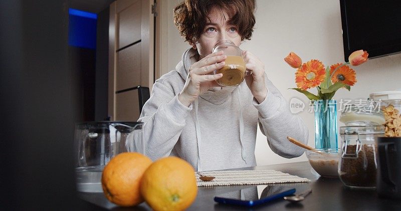 一位女士正在吃有玉米片、牛奶、速溶咖啡和新鲜橙子的早餐