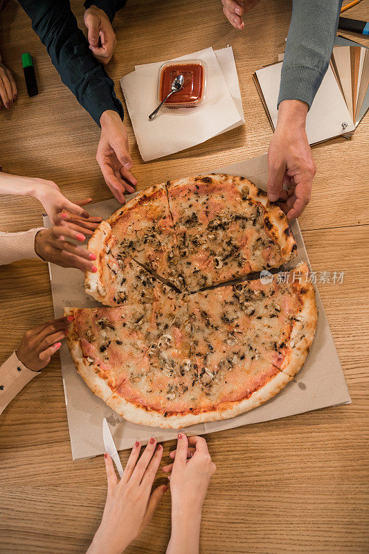 在办公室的午餐休息时间，一群同事每人吃一片披萨