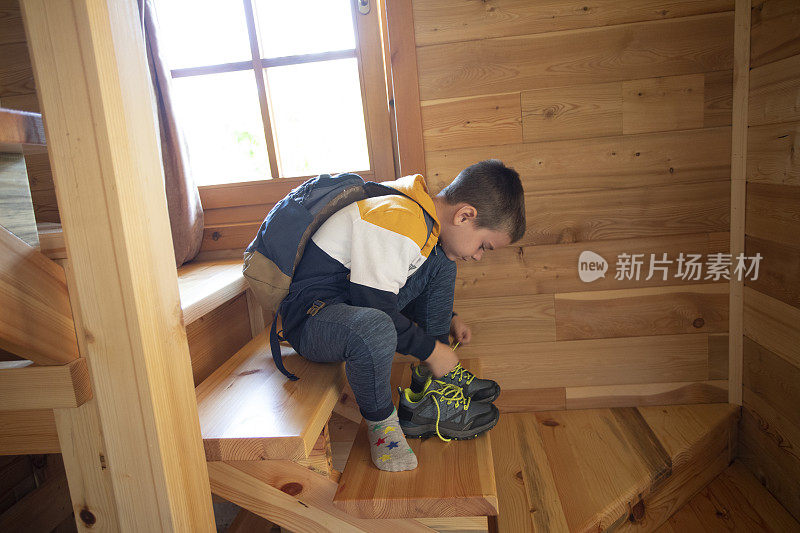 一个六岁的小男孩正在为第一天上学做准备