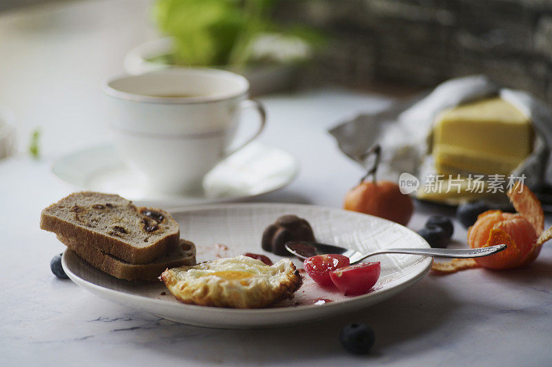 自制早餐:烤葡萄干面包、煎鸡蛋、黄油和咖啡
