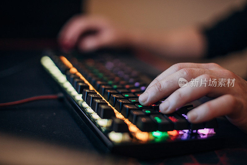 男性玩家使用电脑键盘和鼠标玩游戏