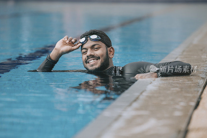 亚洲印度男子运动员游泳运动员微笑着看向公共游泳池