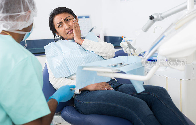 女病人正在跟牙医诉说牙痛