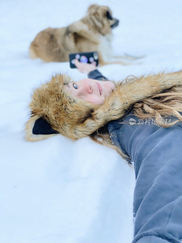 狐狸和猎犬，少女玩和她的狗在雪中拍照。