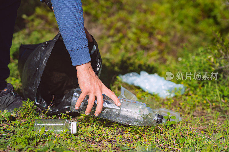 人类正在清理森林里的塑料垃圾。塑料水瓶污染了森林。行星保健