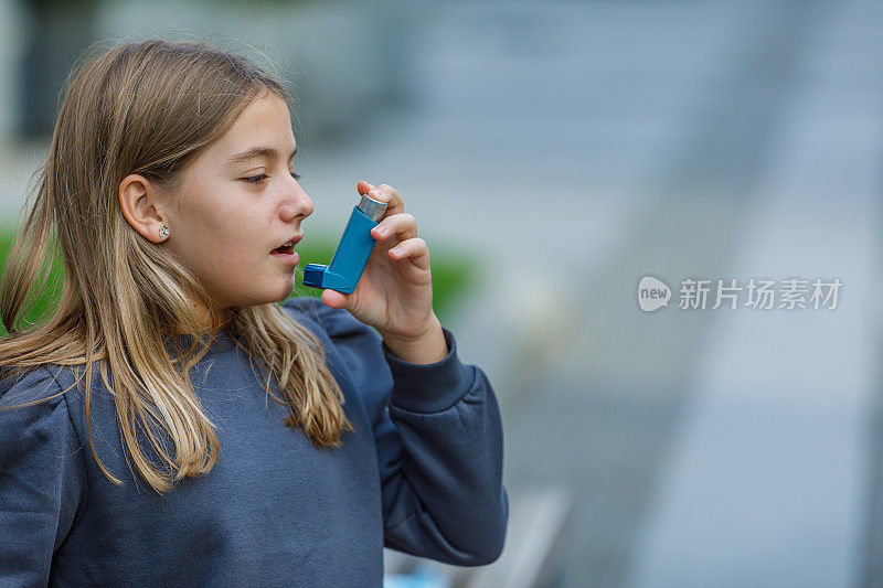 有呼吸问题的女孩正在使用哮喘吸入器。