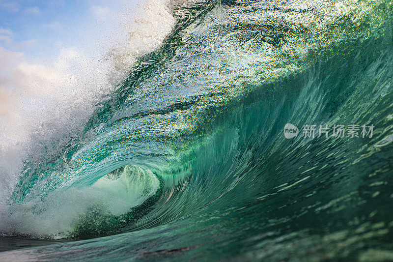 明亮的蓝色透明波浪有力地冲进海洋