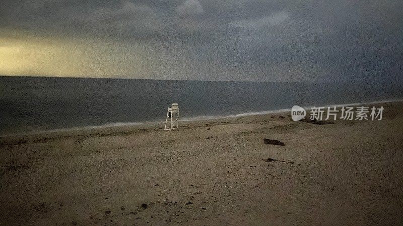 海滩上孤独的救生员椅子在阴沉沉的黄昏