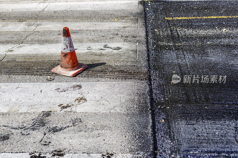 柏油马路旁的人行横道。马德里大街上的沥青工程，信号锥