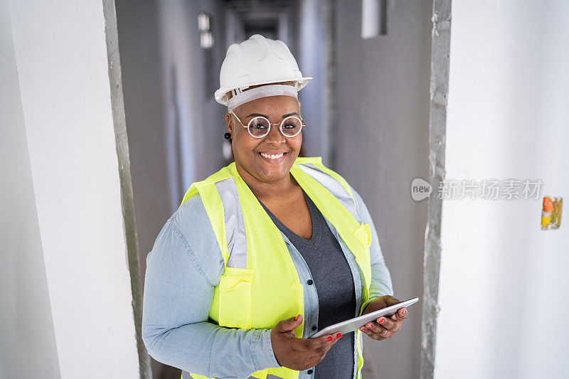 一名女性建筑工人在建筑工地使用数码平板电脑