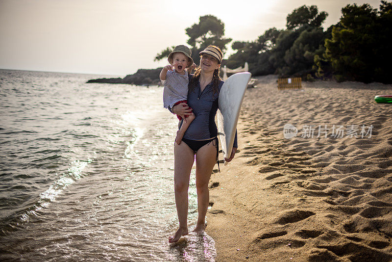 冲浪妈妈和一个小男孩在海滩上