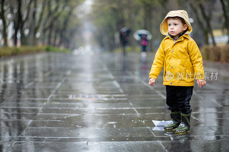 孩子们在水坑里玩纸船