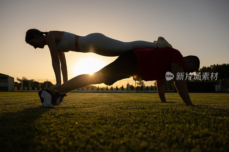 一对年轻的夫妇，在日落时分一起在大自然中锻炼