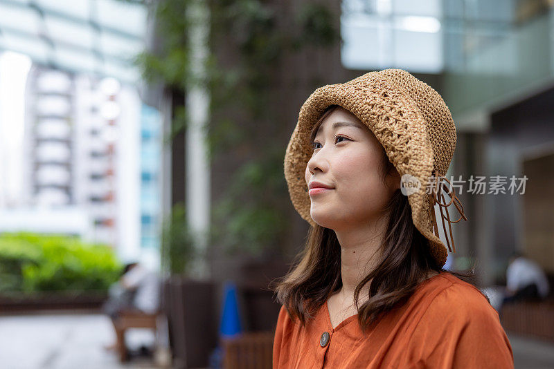 在城市里坐在长椅上等待的自由职业女性