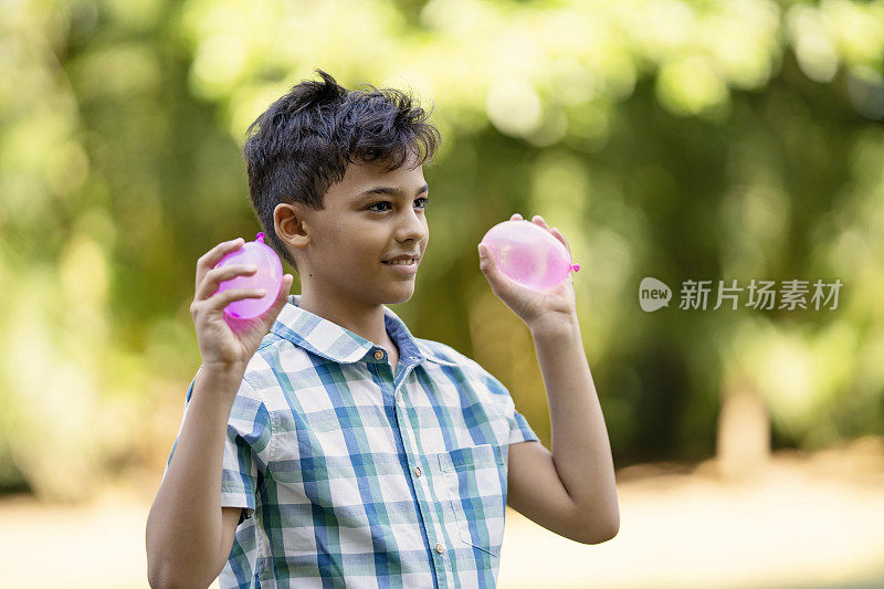 男孩在他们的院子里玩水战