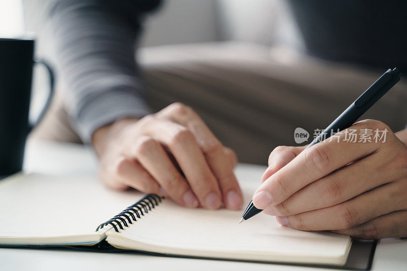 左撇子在桌上的笔记本上写字