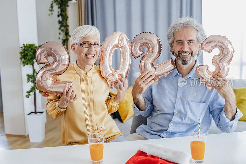 一对老夫妇庆祝2023年新年的画像。