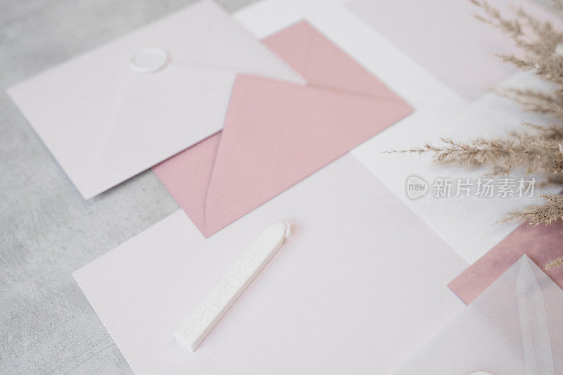 俯视图组成不同大小的纸张，白色和粉色信封用蜡封好，封好蜡。
